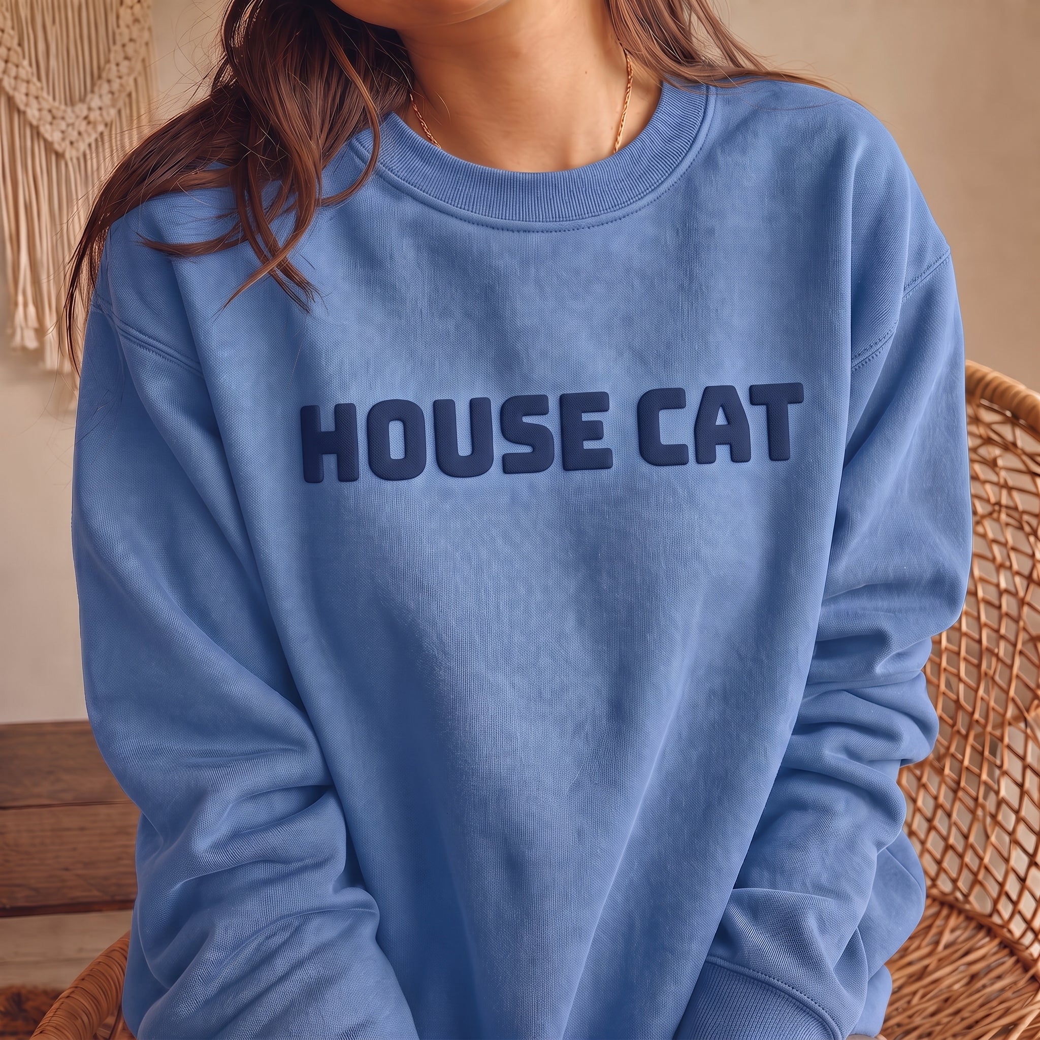 Woman wearing Carolina blue HOUSE CAT puff print sweatshirt, a cozy unisex cat lover crewneck with raised navy lettering and casual everyday style.