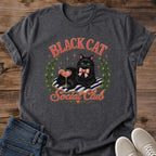 Black Cat Graphic Tee Women Shirt Design Luxurious Cat With Green Eyes Pink Cocktail Glass Striped Cushion Detail Pink Bow Accent Olive Wreath Frame Perfect Cat Lover Gift Casual Wear Essential Coquette Style Fashion Feminine Aesthetic Cute