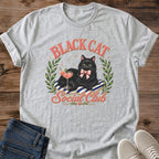 Graphic Tee Women Black Cat Shirt Design Cute Animal Themed Clothing Luxurious Cat With Green Eyes Pink Cocktail Glass Striped Cushion Detail Pink Bow Accent Olive Wreath Frame Coquette Fashion Style Perfect Cat Lover Gift Casual Wear