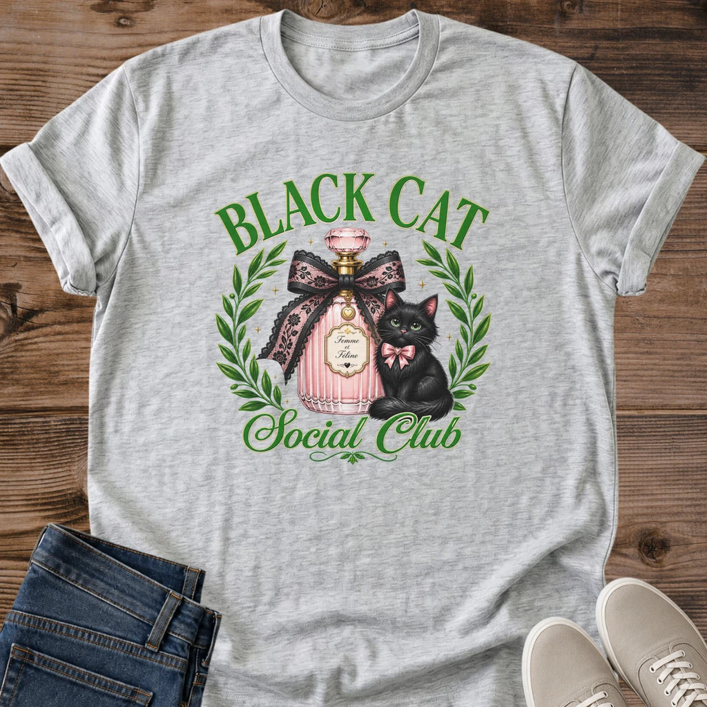 Feminine Cat Shirt Aesthetic Graphic Tee Design Black Cat With Green Eyes Coquette Style Fashion Statement Perfume Bottle Art Detail Pink Bow Accent Laurel Wreath Frame Cat Lover Gift Casual Wear Essential Soft Girl Style Unique Design