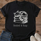 Literary Theme Shirt Casual Cotton Tee Featuring Hand Drawn Cat Design Atop Book Stack Soft Breathable Ring Spun Cotton Construction Comfortable Crew Neck Style Perfect Gift For Book Lovers Vintage Muted Contrast Artwork Cozy Bookish
