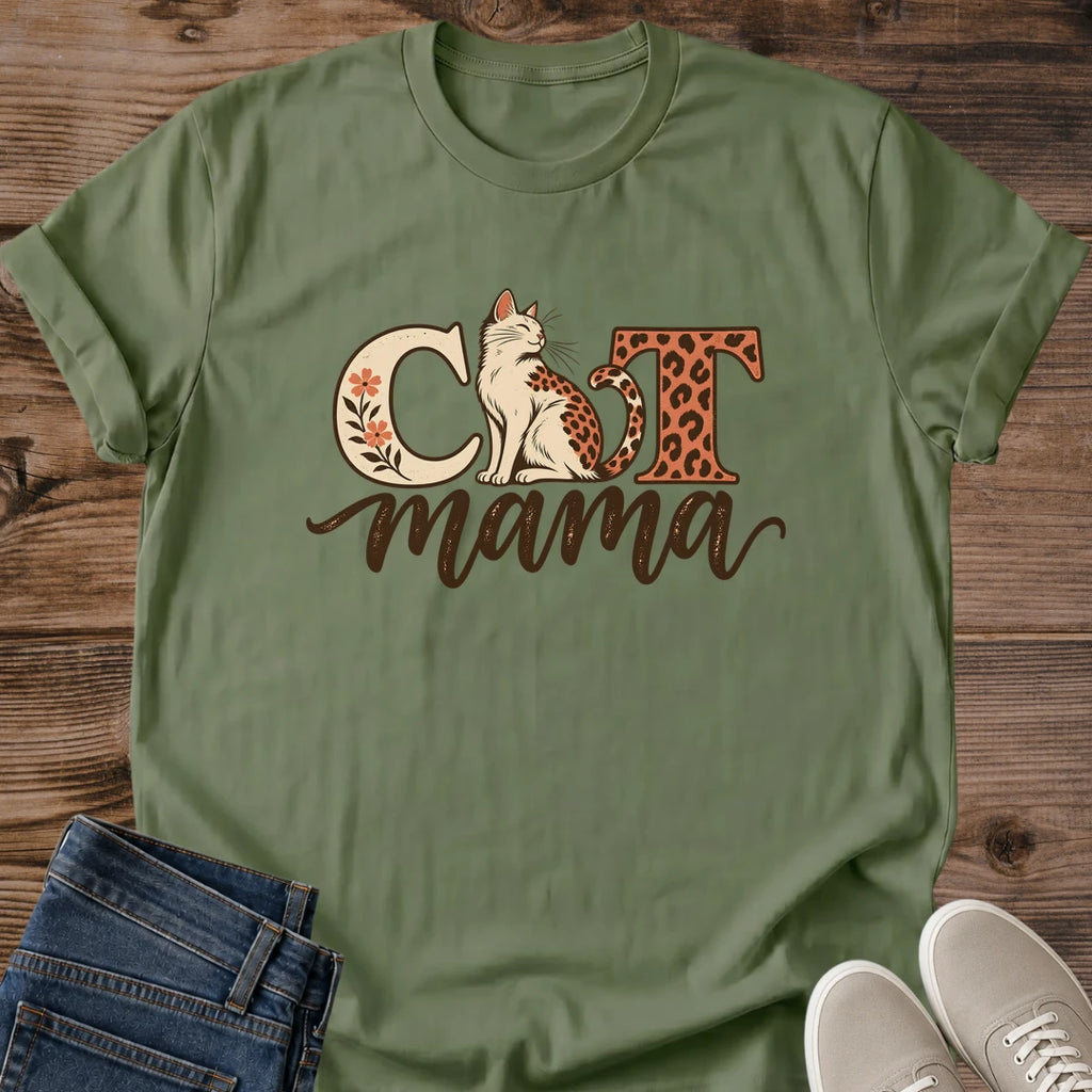 Military green Cat Mama T-shirt flat lay with a seated leopard-spotted cat, cream floral C, rust leopard-print T and brown mama script.