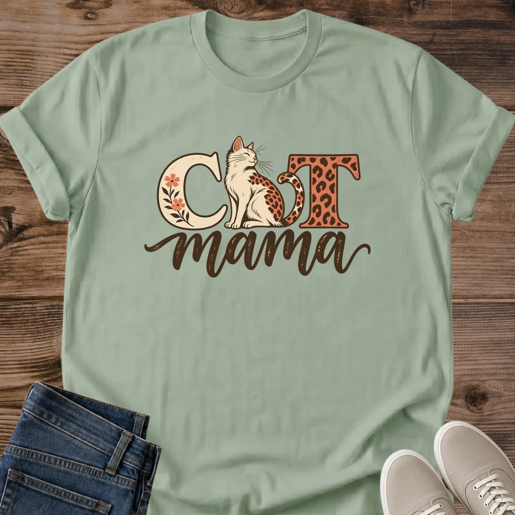 Sage green Cat Mama T-shirt flat lay with a seated leopard-spotted cat, floral C, leopard-print T and brown script mama.