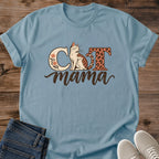 Stone blue Cat Mama T-shirt flat lay with a seated leopard-spotted cat between floral and animal-print letters, above brown script mama.