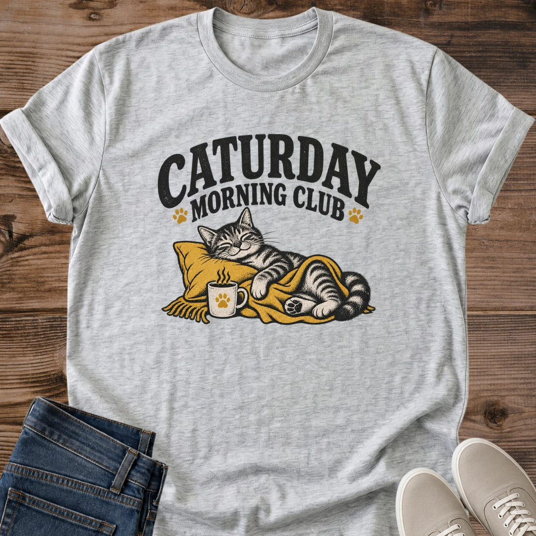 Cozy Cat Shirt Caturday Morning Club Graphic Tee Lounging Tabby Cat Wrapped In Blanket With Warm Coffee Mug Vintage Screen Print Design Cat Lover Gift Softstyle Ring Spun Cotton Relaxed Fit Casual Weekend Wear Cat Mom Coffee Tee