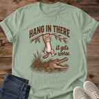 Sage green Hang In There Gator cat T-shirt with vintage tabby above an alligator and “It gets worse” sarcastic graphic