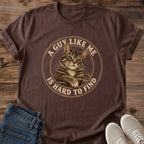 Dark Chocolate T-shirt flat lay featuring a brown tabby with crossed front paws inside a tan circular border reading A Guy Like Me Is Hard to Find.