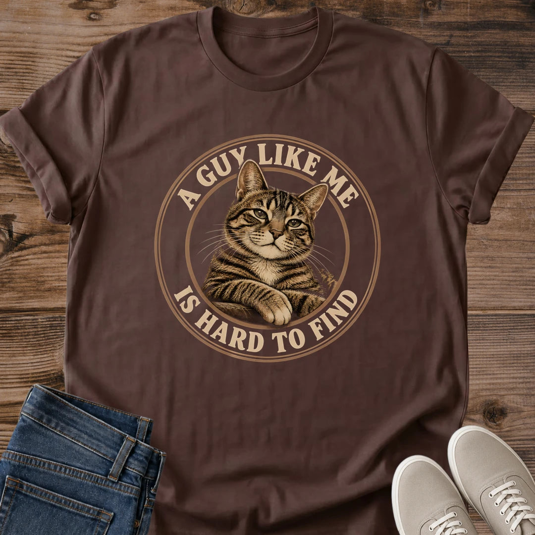 Dark Chocolate T-shirt flat lay featuring a brown tabby with crossed front paws inside a tan circular border reading A Guy Like Me Is Hard to Find.