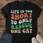 Retro Groovy Cat Shirt Vintage Typography Design Wavy Text Pattern Funny Cat Rescue Tee Multi Cat Owner Apparel Sage Green Coral White Colors Cat Lover Fashion Statement Casual Wear Gift Animal Shelter Volunteer Shirt Cat Mom Dad Style