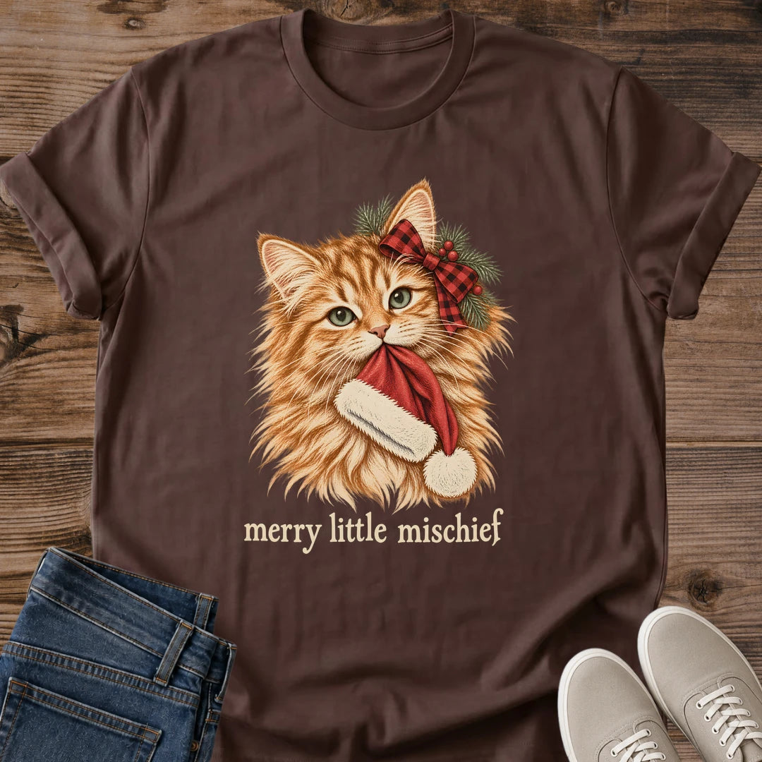 Dark chocolate Merry Little Mischief Christmas cat T-shirt flat lay featuring an orange tabby with a red plaid bow holding a Santa hat.