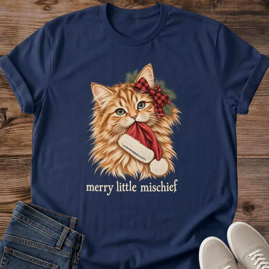 Navy Merry Little Mischief Christmas cat T-shirt flat lay featuring an orange tabby with a red plaid bow holding a Santa hat.
