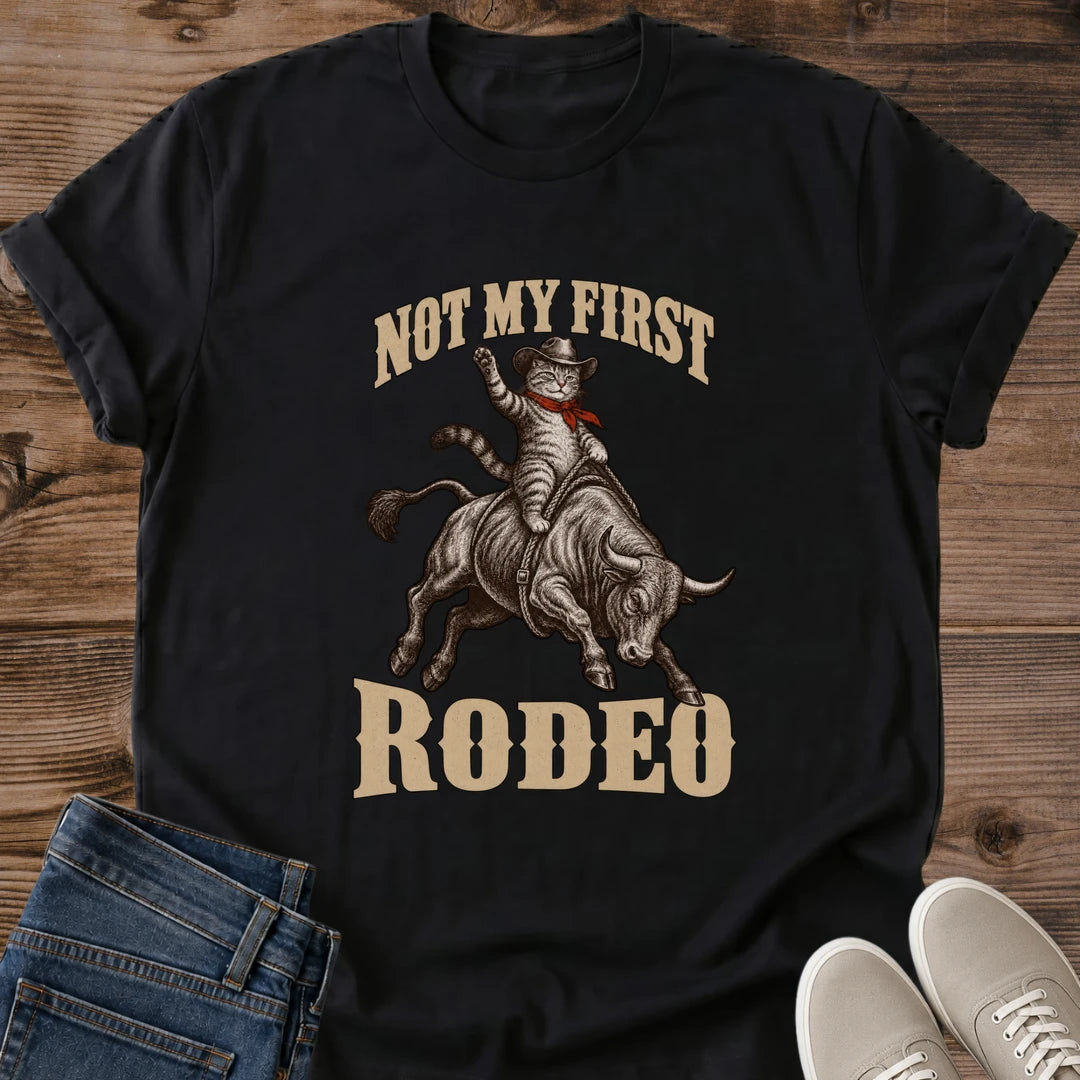 Not My First Rodeo Cat Shirt Black Funny Cowboy Cat Tee Tabby Cat Riding Bull Graphic Vintage Western Cat Shirt Rodeo Cat Tee Country Cat Lover Gift Cowgirl Cat Mom Shirt Cat In Cowboy Hat Gildan 64000 Softstyle Unisex Cat Whisker Co