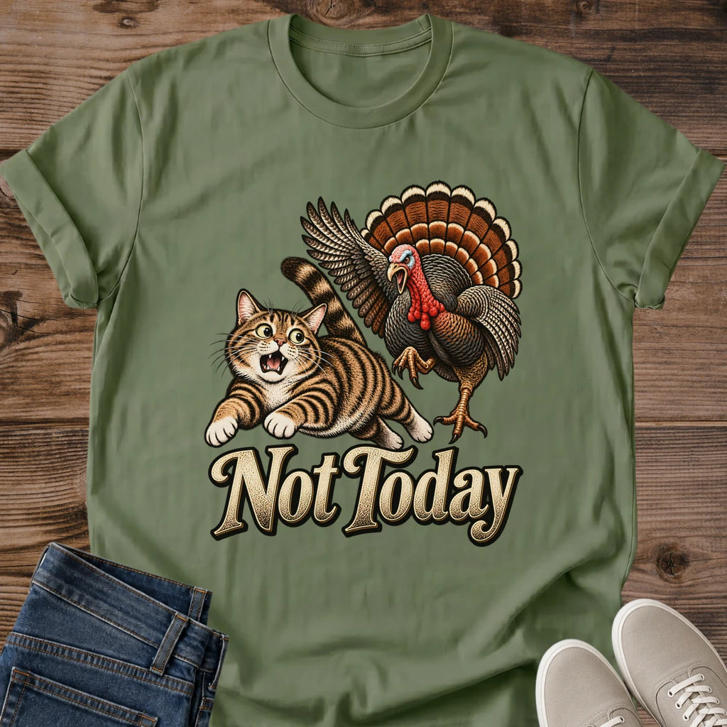 Military Green olive Gildan 64000 unisex Thanksgiving cat T-shirt shown in a front flat lay with rolled sleeves on a wooden background. The centered vintage graphic features a wide-eyed tabby running from a turkey with raised wings, a red wattle and a fanned brown-and-orange tail, above cream "Not Today" lettering with dark edging. Blue jeans and light gray sneakers complete the styling.