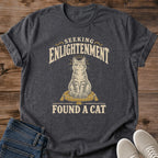 Spiritual Humor Graphic Tee Funny Cat Shirt Vintage Style Design Seeking Enlightenment Found Cat Message Perfect Cat Lover Gift Soft Cotton Fabric Comfortable Casual Wear Centered Illustration Dark Background Muted Warm Tones Quirky Novelty