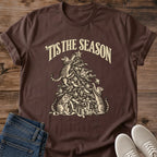 Dark Chocolate 'Tis the Season Christmas cat T-shirt flat lay with cream vintage-style artwork of cats climbing and playing in a decorated tree above gifts.