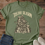Military Green 'Tis the Season Christmas cat T-shirt flat lay with cream vintage-style artwork of cats climbing and playing in a decorated tree above gifts.