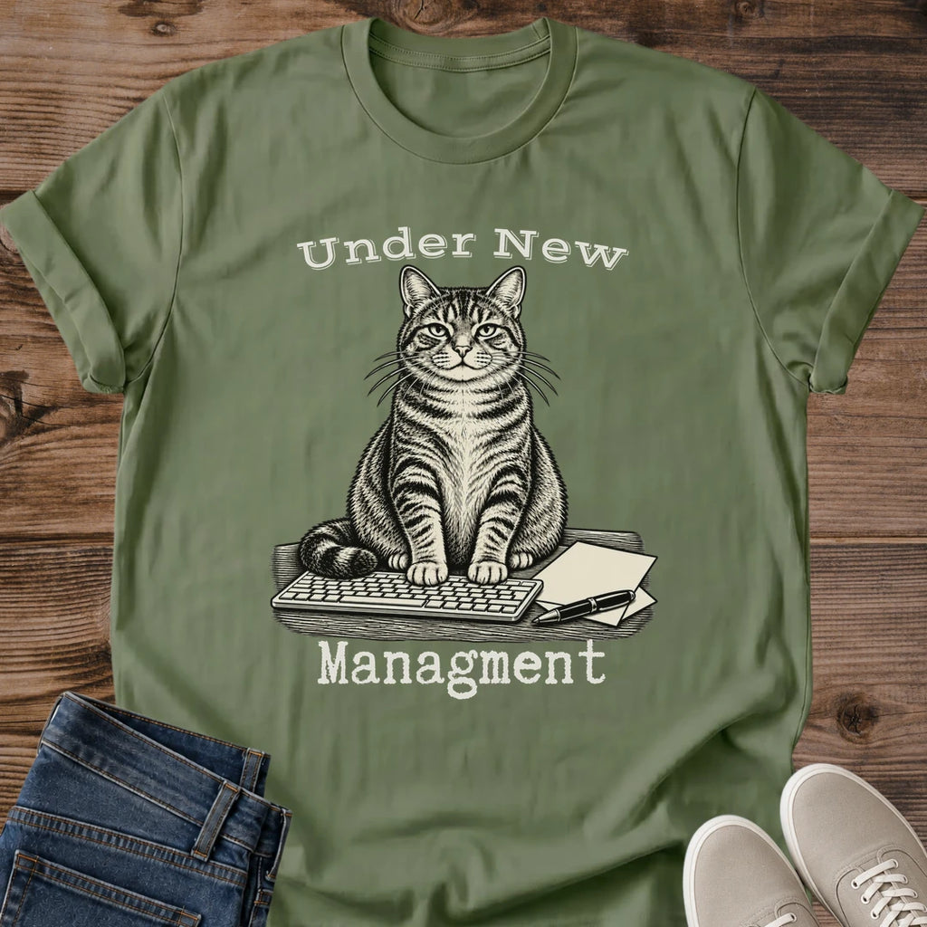 Under New Management Cat Shirt In Black Funny Work From Home Tee With Vintage Engraved Tabby Cat Sitting On A Keyboard And Paperwork Typewriter Lettering Cat Boss Graphic Tee Gildan 64000 Softstyle Cat Whisker Co